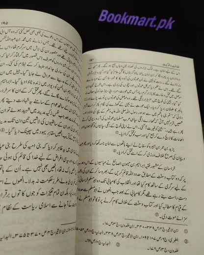 Open book with dense Urdu text on cream pages, paperback format